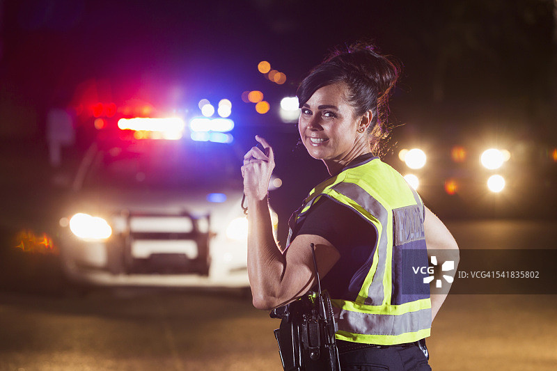 女警察晚上，巡逻车上亮灯图片素材