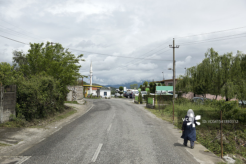 一名妇女走在阿尔巴尼亚的穆里坎大街上图片素材