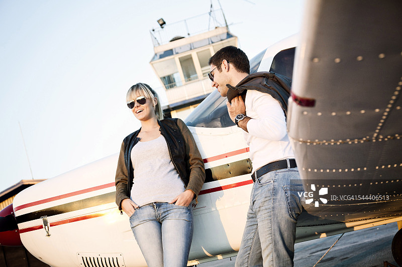 一对年轻夫妇站在螺旋桨飞机旁图片素材