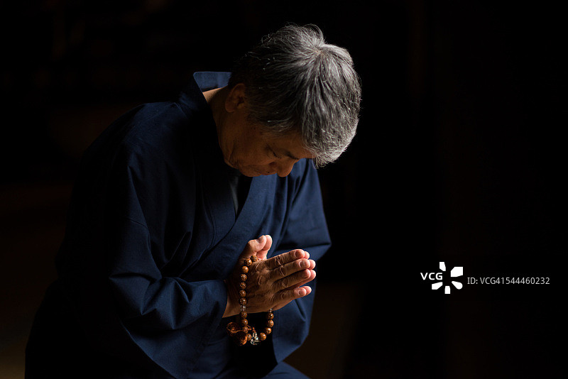 一名日本老人在寺庙里祈祷图片素材