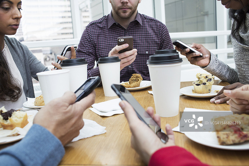商务人士在早餐时间使用手机图片素材