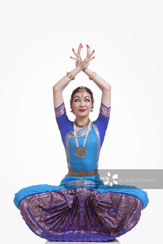 全长的年轻女子表演印度Bharat Natyam舞蹈在白色的背景图片素材