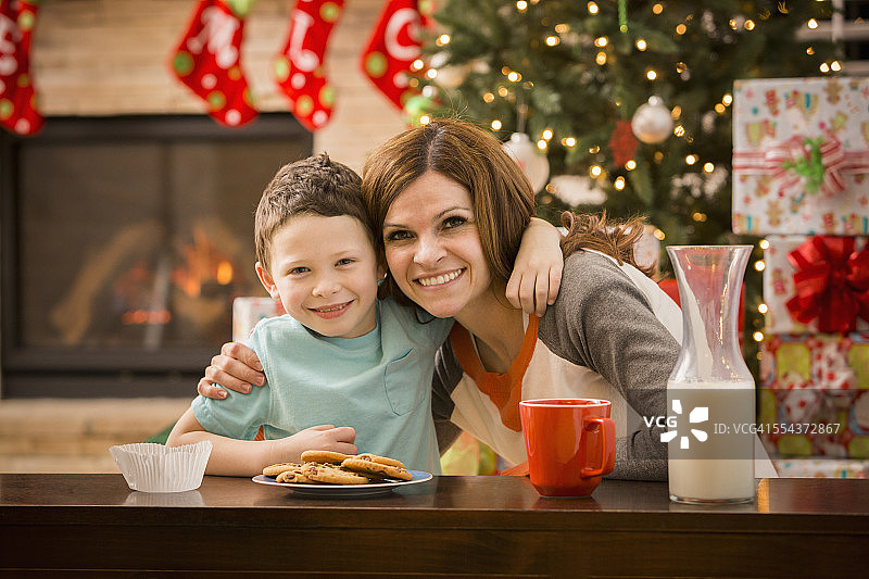 白人母亲和儿子在圣诞节给圣诞老人留下饼干和牛奶图片素材