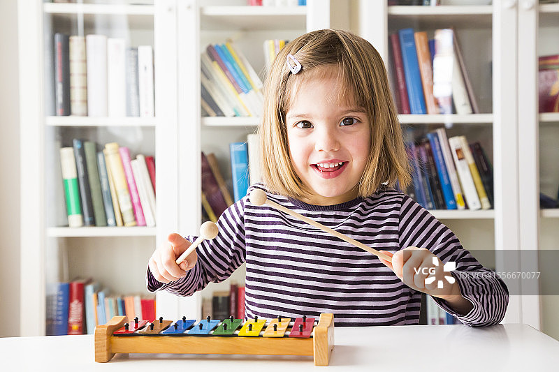 快乐的小女孩玩木琴的肖像图片素材