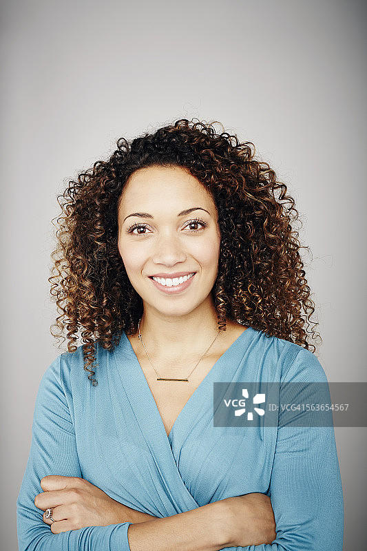 一个微笑着的混血儿女人的工作室肖像图片素材