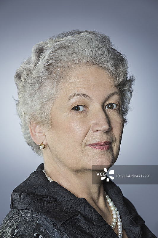 灰色背景下自信的资深女性肖像图片素材