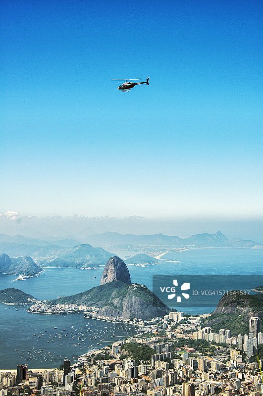 一架直升飞机在甜面包山和里约热内卢上空盘旋图片素材