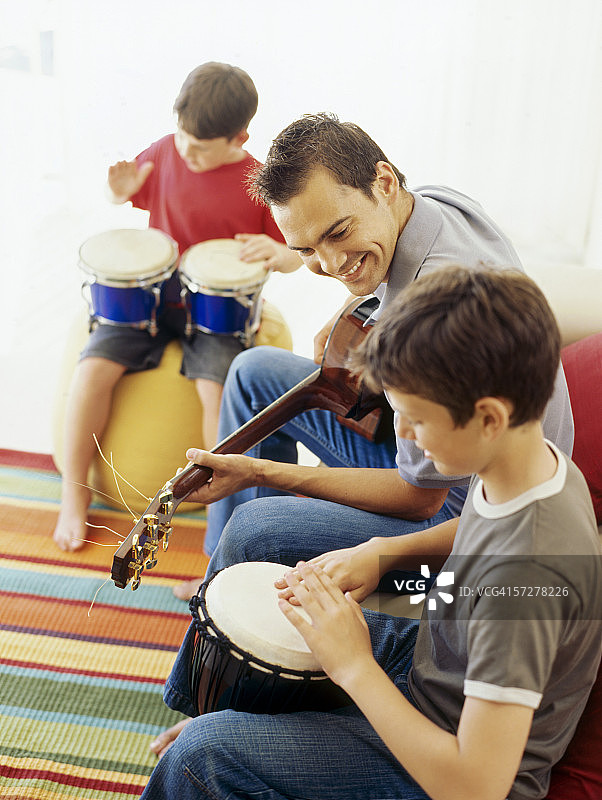 侧面是两个男孩和他们的老师在演奏乐器图片素材