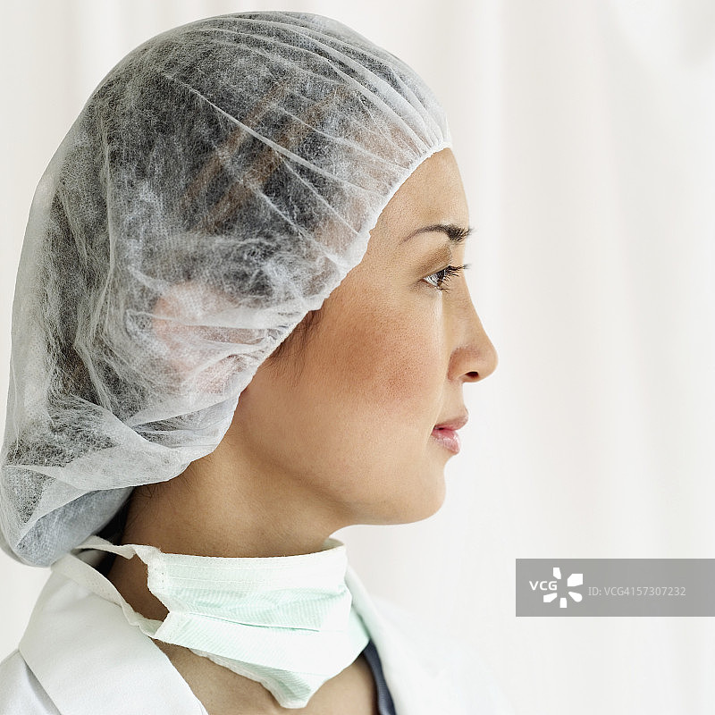 一个穿着手术服的年轻女外科医生的侧影图片素材