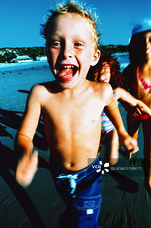 一个小男孩的肖像(4-6)在海滩上跑步图片素材