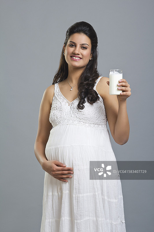 一个孕妇拿着一杯牛奶的肖像图片素材