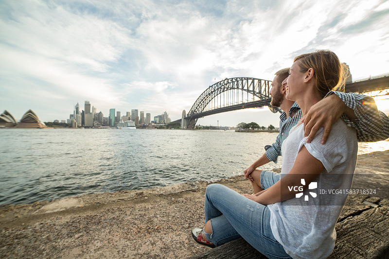 一对白种人夫妇在夕阳下眺望悉尼的天际线图片素材