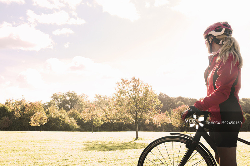 一位骑自行车的女性停下来欣赏风景。图片素材