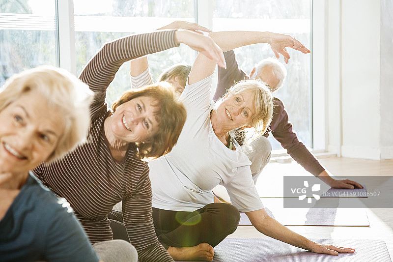 一群活跃的老年人在瑜伽课上锻炼。图片素材