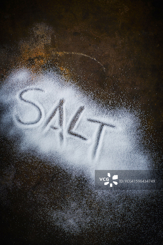 “盐”这个词用盐写在生锈的金属上图片素材