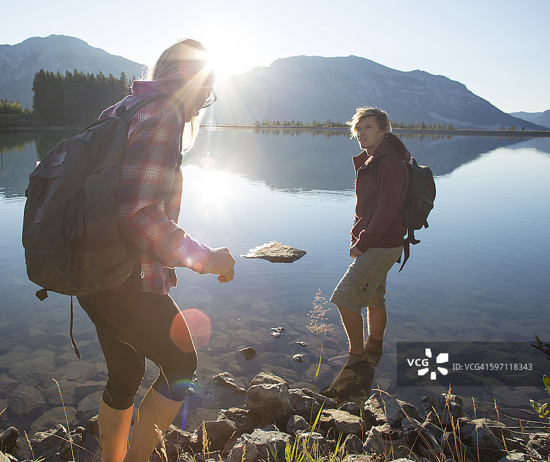 徒步旅行者在湖边的岩石上保持平衡图片素材