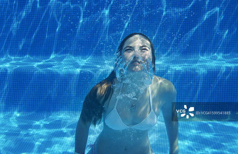 水下视图的女孩水下游泳在游泳池图片素材