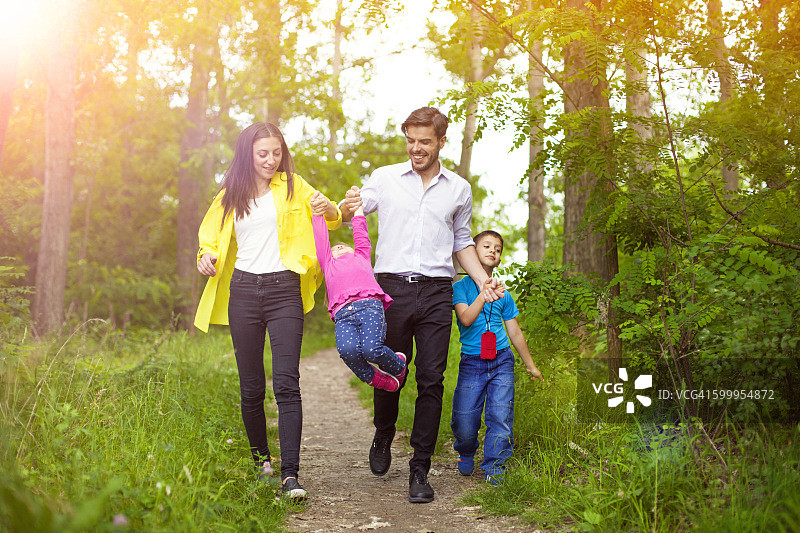 快乐的一家人在大自然中享受他们的夏日漫步。图片素材