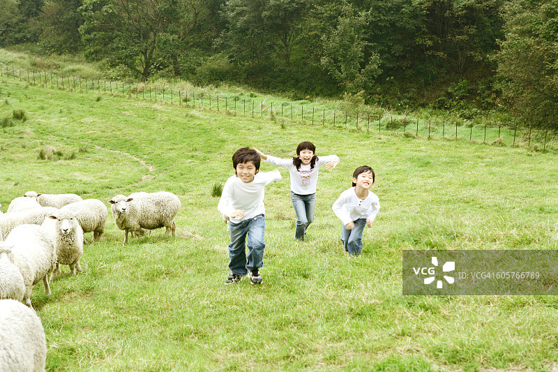 儿童(6-11岁)在草地上奔跑，高视阔步图片素材