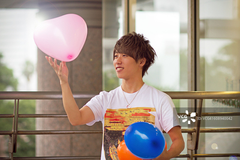 亚洲小男孩玩彩色气球图片素材