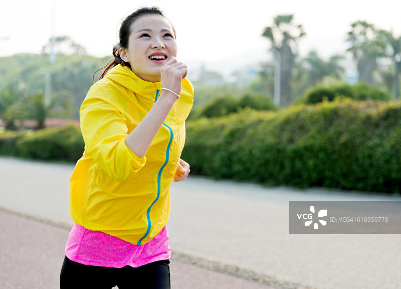 年轻漂亮的亚洲女人在公园里跑步图片素材