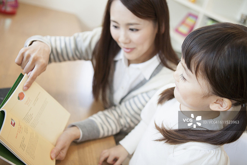 妈妈和一个日本女孩在看书图片素材
