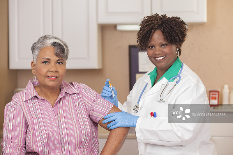 医生或护士在诊所给病人注射流感疫苗。图片素材