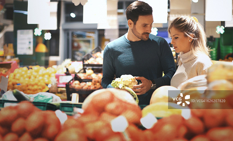 夫妇在超市买蔬菜。图片素材