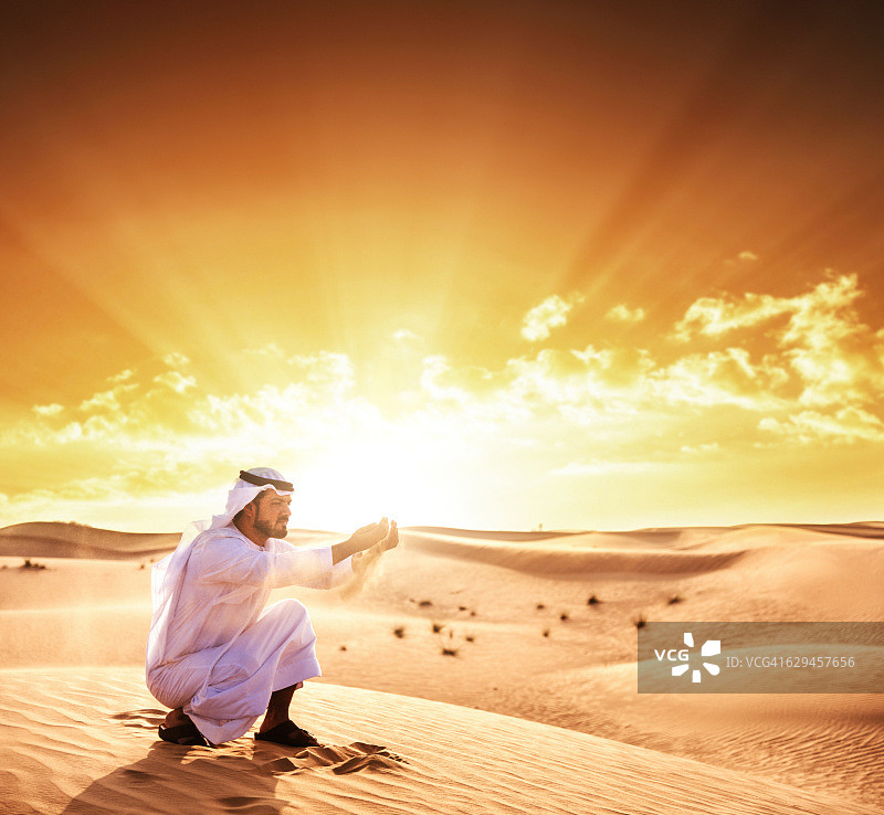 阿拉伯酋长在沙漠上祈祷图片素材