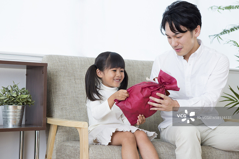 一个日本女孩从他父亲那里得到了一份礼物图片素材