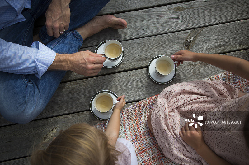 父亲和女儿们在花园里喝茶图片素材