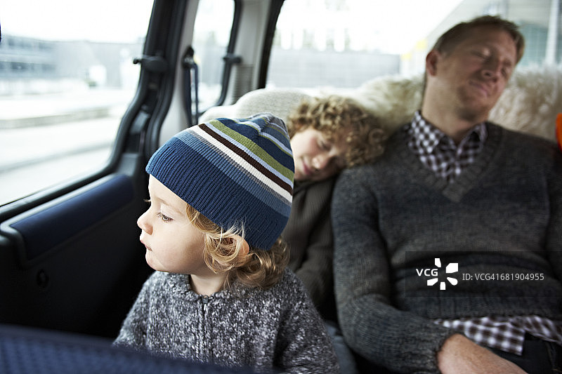 熟睡的父亲和他的儿子们坐在车后座上图片素材
