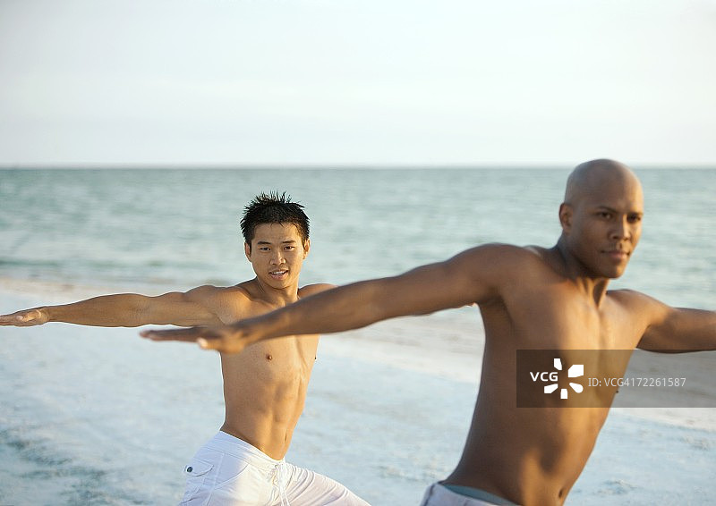 两个男人在海滩上做放松运动图片素材