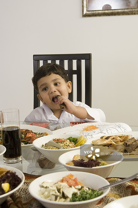 小男孩在餐桌上吃饭图片素材