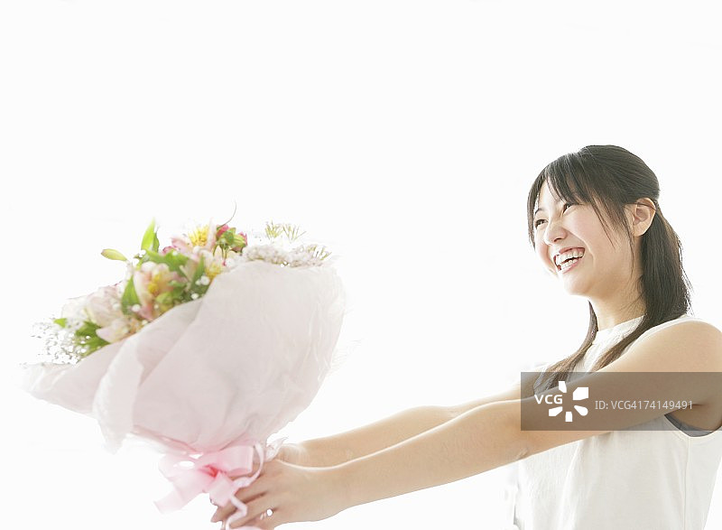 日本年轻女子拿着捧花微笑，肖像图片素材