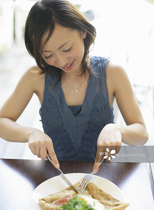 一个在咖啡馆吃东西的日本女人图片素材