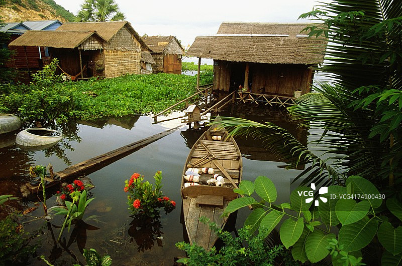 柬埔寨暹粒一个被洪水淹没的村庄，房子前面的一艘船的高角度视图图片素材