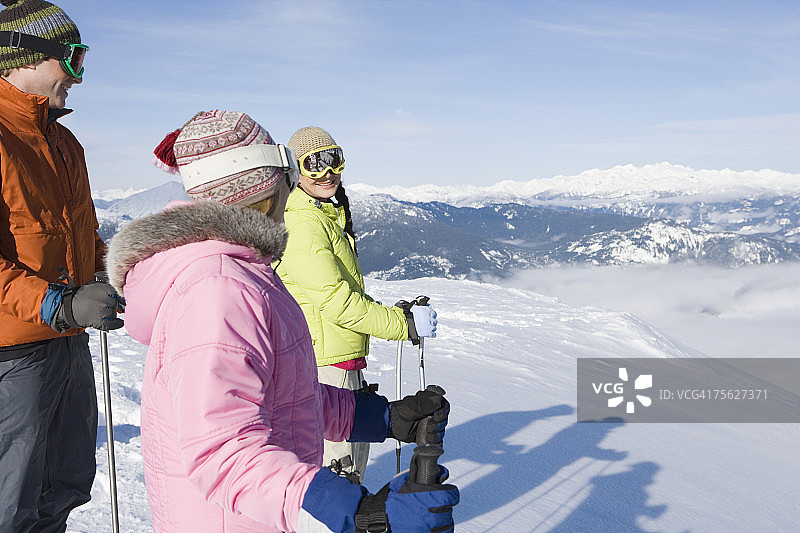 三个年轻人冬天在山上滑雪，侧景图片素材