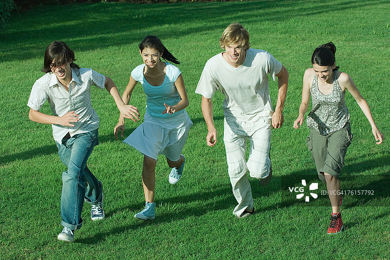 "一群年轻的朋友，一起跑过草地"图片素材