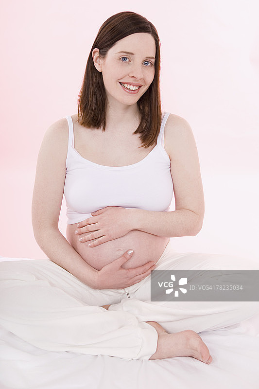 一幅年轻孕妇赤裸着肚子的肖像图片素材