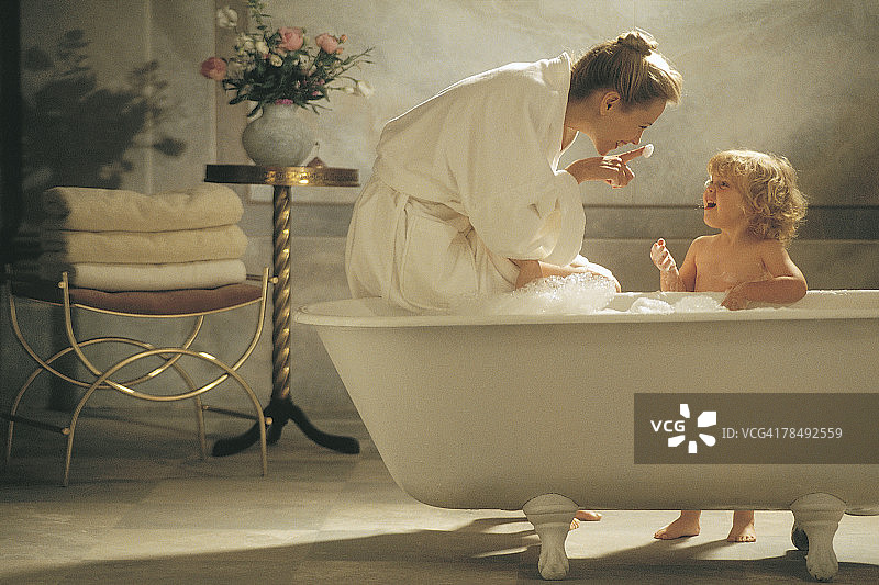 母亲和孩子在浴缸旁图片素材