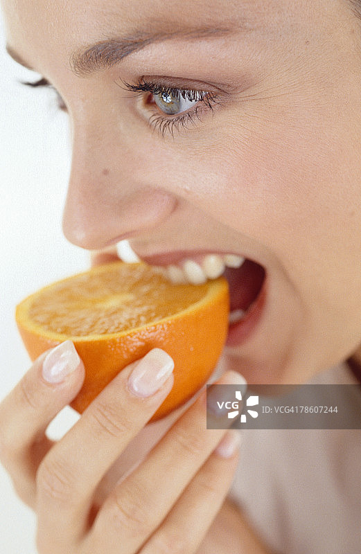 微笑着吃橘子的女人图片素材