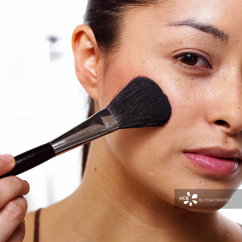 女人用化妆刷化妆图片素材