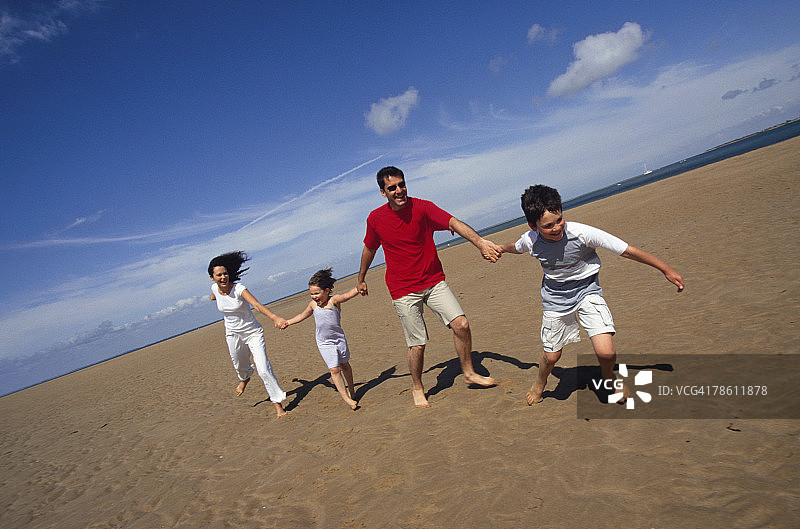 一家人一起沿着海滩跑步图片素材