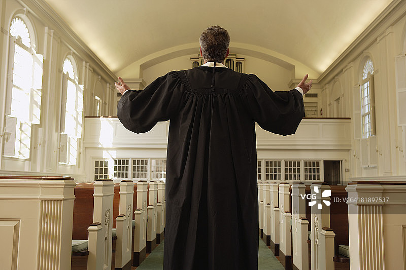 在教堂里举起手臂的牧师图片素材