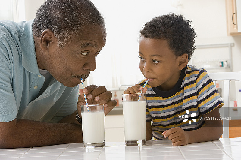 非洲祖父和孙子喝牛奶图片素材