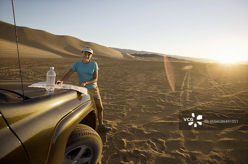 沙漠里的女人带着SUV和地图图片素材