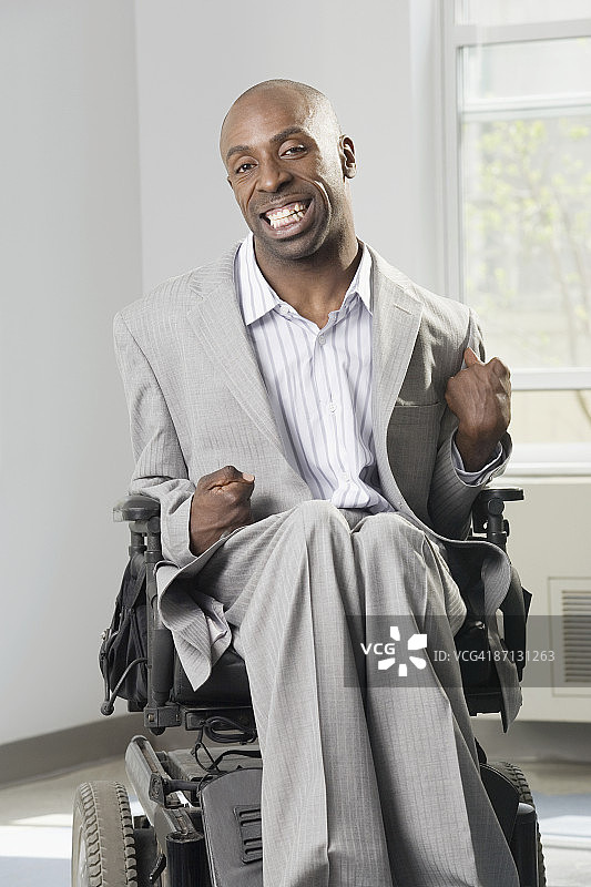 患有脑瘫的商人微笑着坐在轮椅上图片素材
