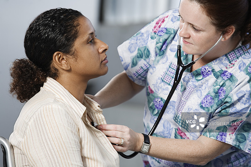 护士用听诊器检查一位女性病人图片素材
