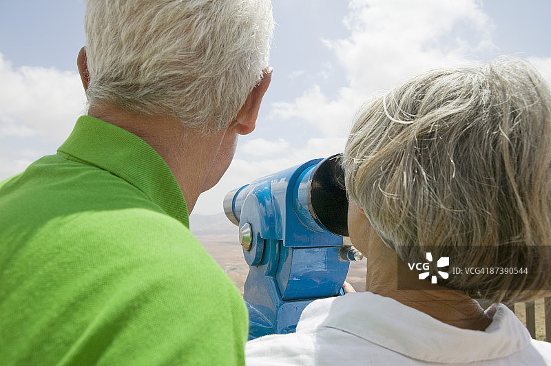 成熟的夫妇透过望远镜看图片素材